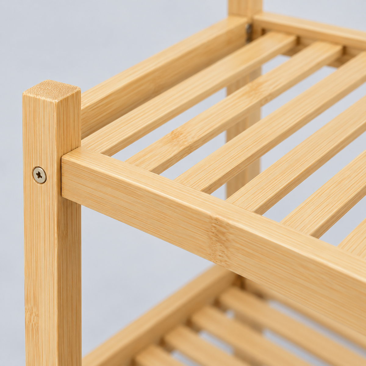Close-up of the bamboo shoe rack corner: square post, front rail and thin slats running front to back