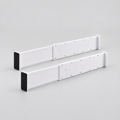 Two long white expandable drawer dividers standing side by side on a light grey background, each with a black end pad and a push-down lock