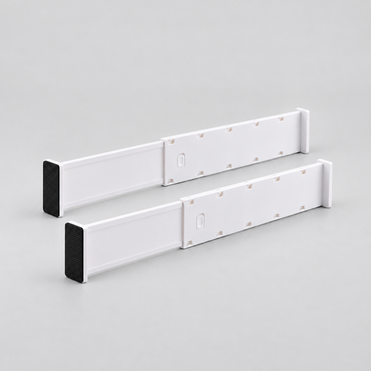 Two long white expandable drawer dividers standing side by side on a light grey background, each with a black end pad and a push-down lock