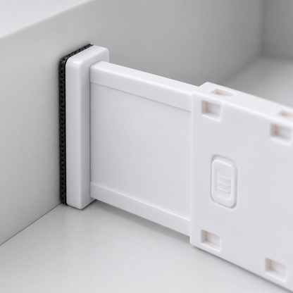 Close-up of a drawer divider end plate with its black dotted pad pressed flat against the drawer wall