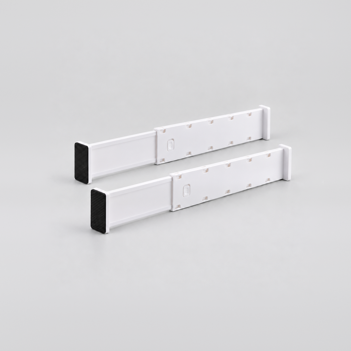 Two short white expandable drawer dividers side by side on a light grey background