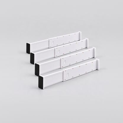Four short white expandable drawer dividers lined up on a light grey background
