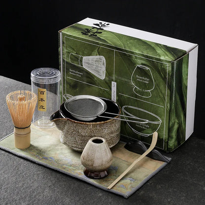 Beige seven-piece matcha kit: spouted bowl with sifter, bamboo whisk, beige whisk holder, bamboo scoop, scoop rest and printed cloth