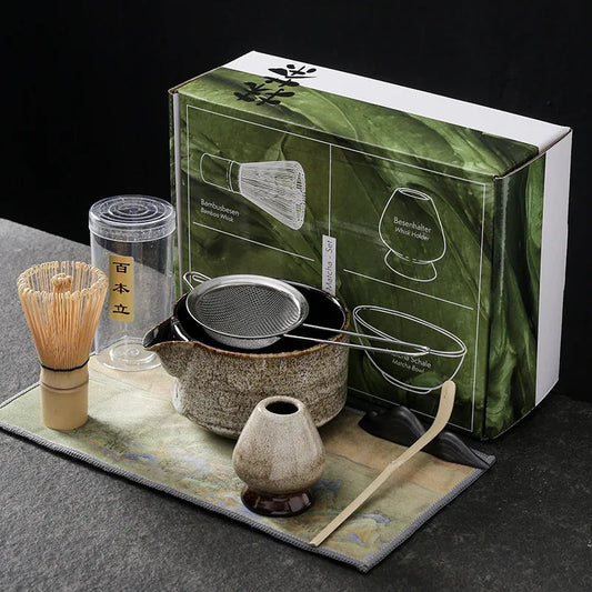 Beige seven-piece matcha kit: spouted bowl with sifter, bamboo whisk, beige whisk holder, bamboo scoop, scoop rest and printed cloth