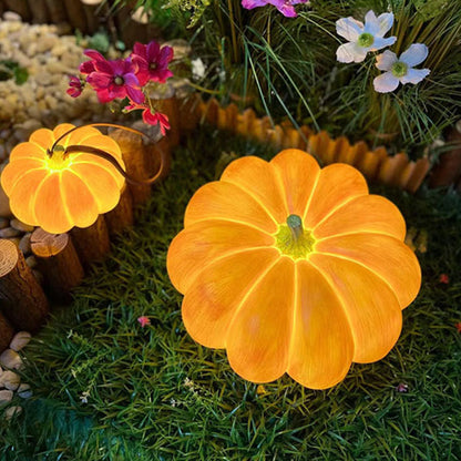 Looking down on a glowing pumpkin lamp on grass, its lobes spreading out from a green stem