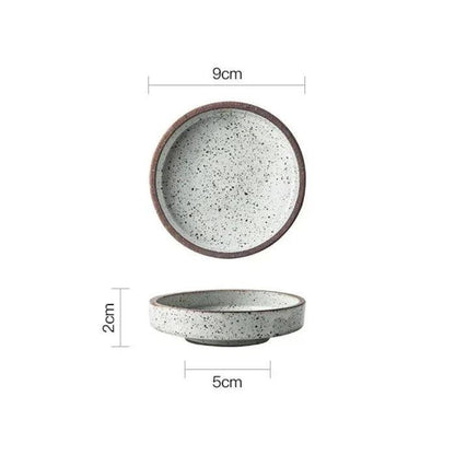 White ceramic dipping bowl with black speckles seen from above and from the side, 9 cm across and 2 cm tall