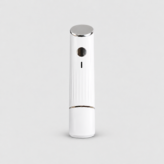 White handheld vacuum sealer standing upright with its cap on, an angled chrome top, a curved chrome band and fine vertical flutes on the lower body, on a light grey background