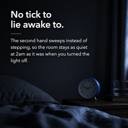Dark quiet bedroom at night with the navy alarm clock on the nightstand. Text reads: No tick to lie awake to.